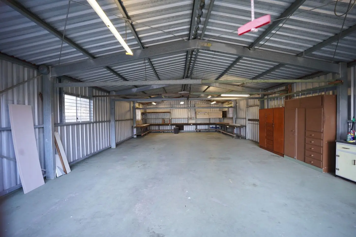 Leere Lagerhalle mit Betonboden und Blechwänden